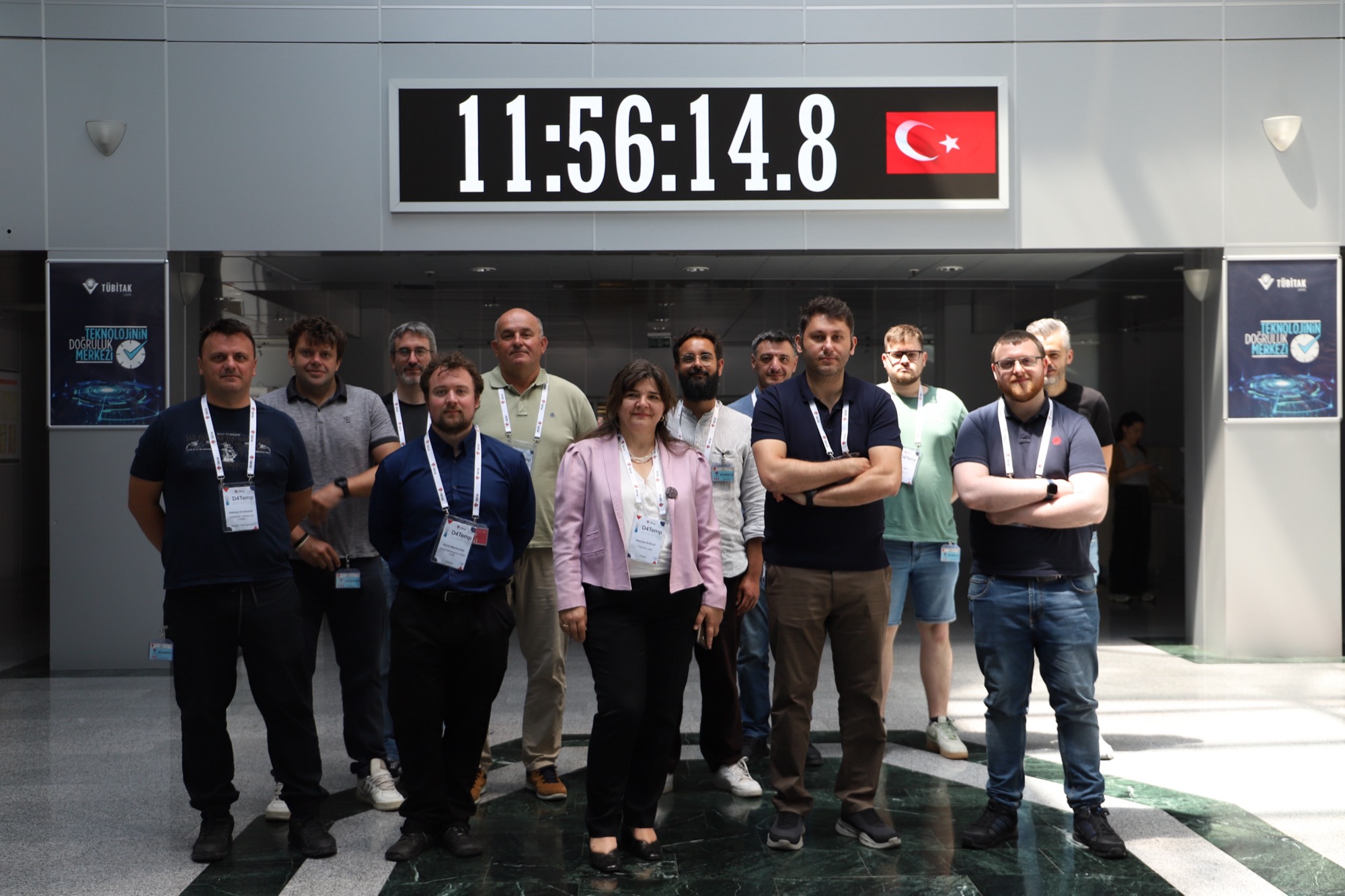 Group photo of the consortium under the TÜBİTAK UME atomic clock display